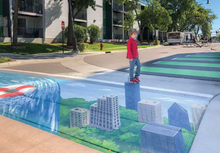 Boy walking down street with chalk drawing of skyline