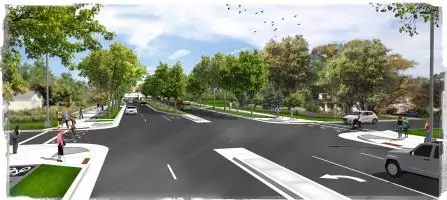 Image of a tree-lined street with multiple lanes, sidewalks, and a bike lane. People are walking and cycling, and a few cars are visible. The sky is partly cloudy, and birds are flying above.