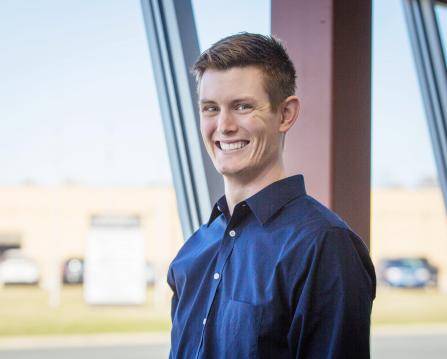 Professional headshot of a man wearing a blue button down shirt