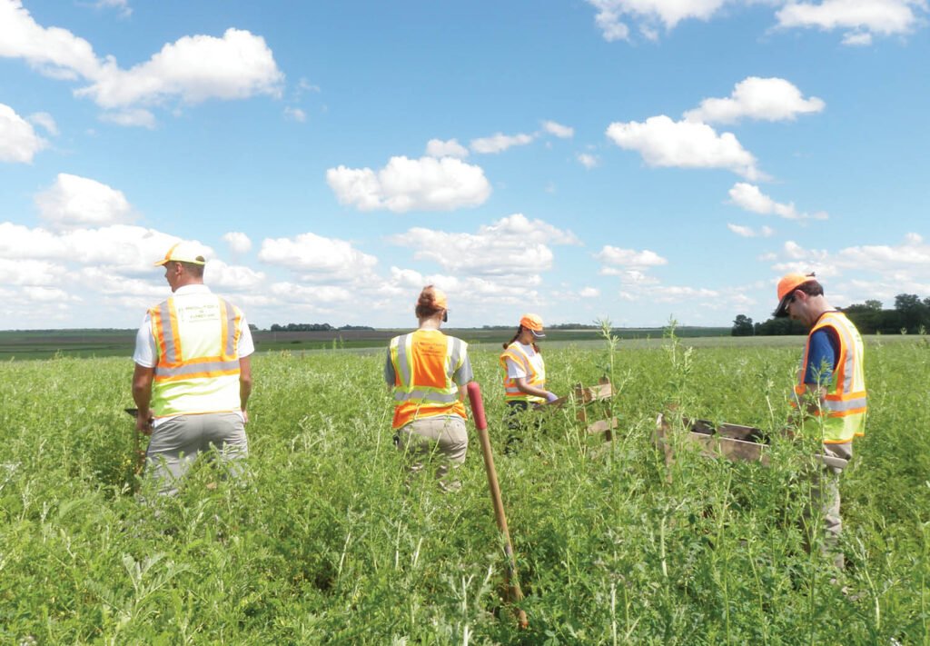 group of people in a field with safety vests on