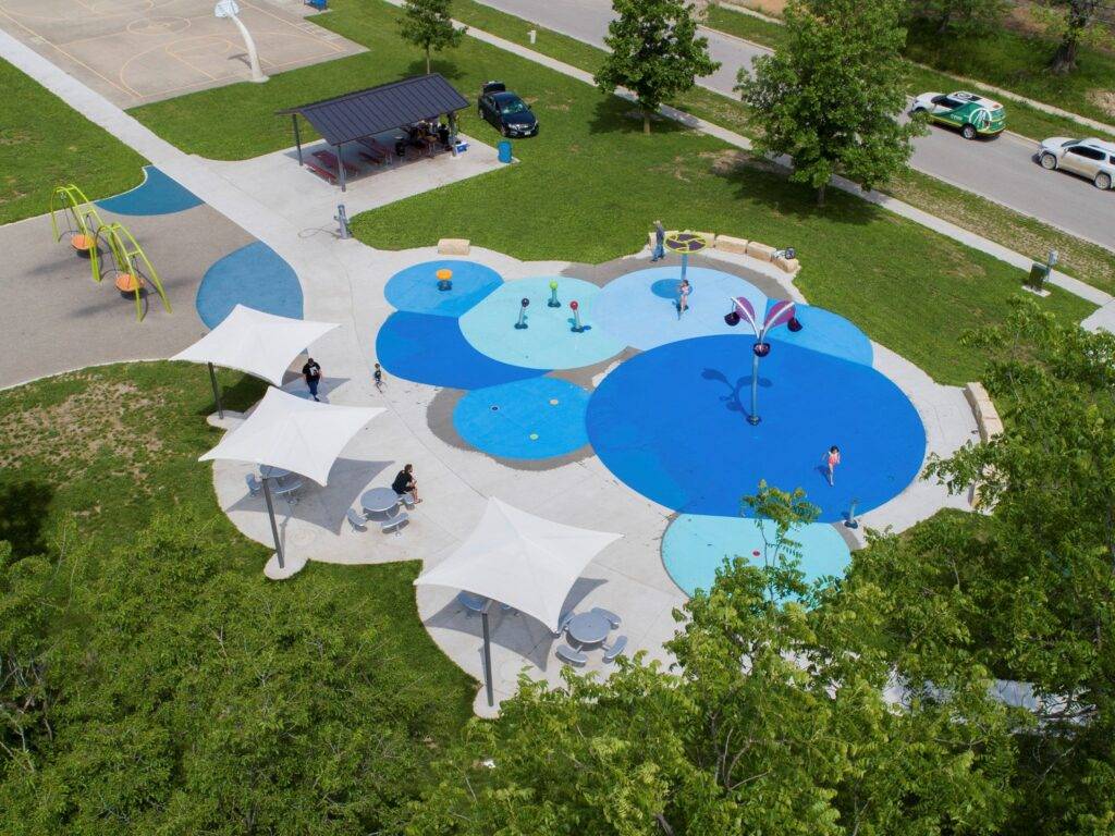 Bates Park featuring a sprayground, new shelter, traditional playground with new swings and surfacing, and shaded seating areas