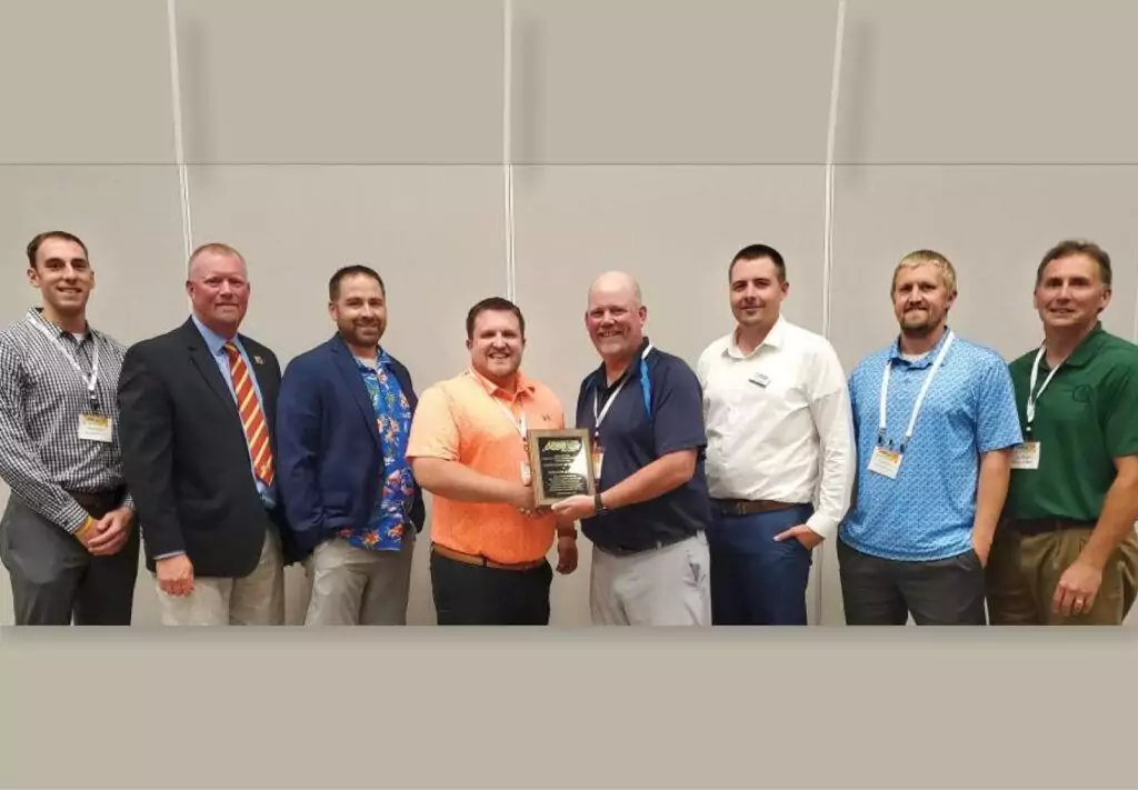 • Iowa employees smiling with plaque