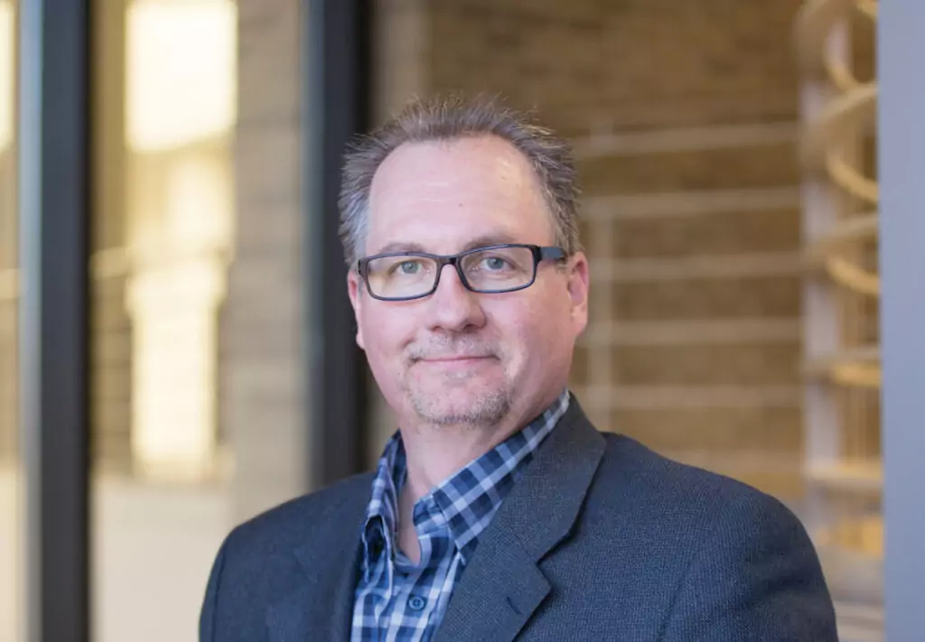 Man wearing glasses smiling outside