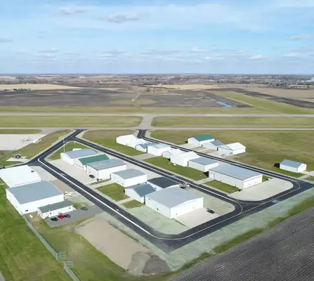 Aerial view of airport with planes, hangars, and runways