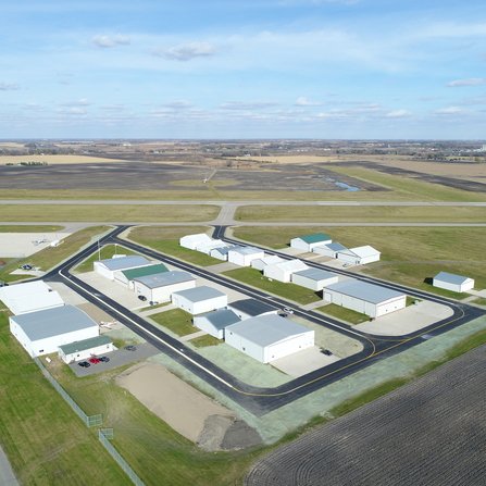 Aerial view of airport with planes, hangars, and runways