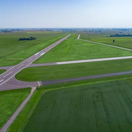A rural runway with taxi lanes nestled amidst vast fields