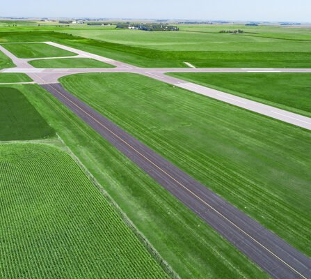 A rural runway and taxi lanes nestled amidst vast fields