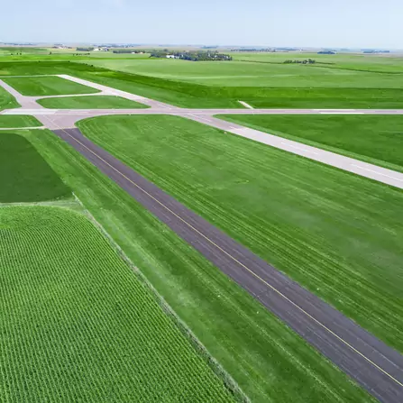 A rural runway and taxi lanes nestled amidst vast fields