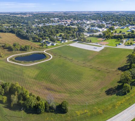 Aerial view of a new complex featuring a walking path and a pond