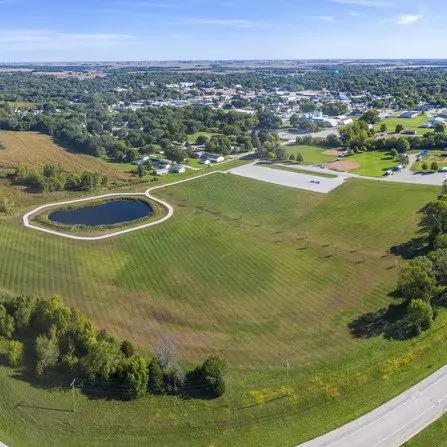 Aerial view of a new complex featuring a walking path and a pond
