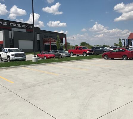 A row of parking spaces with several cars parked in them