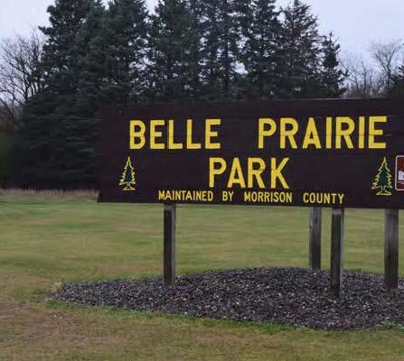 Park sign with trees and grass in the background