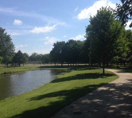 Visualization of a river flowing through a lush park with greenery and a paved walking path