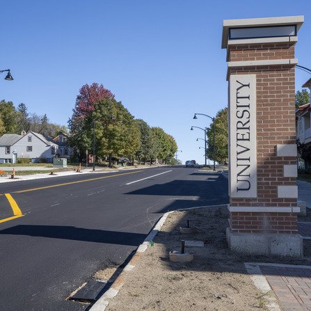 Newly paved street and sidewalk with a monument on display