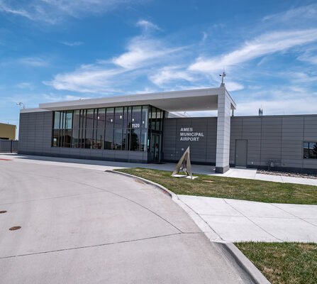 Airport building with glass windows and a metal triangle sculpture in front