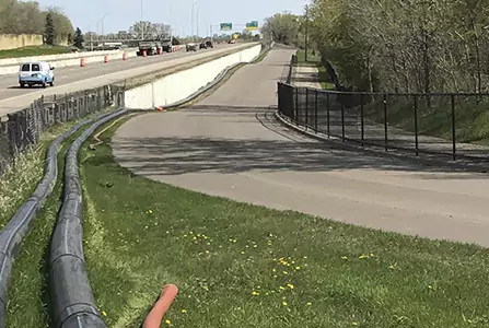 A new road with cement barriers running alongside the highway.