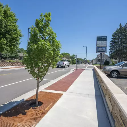 Sidewalk with a tree and brick retaining wall