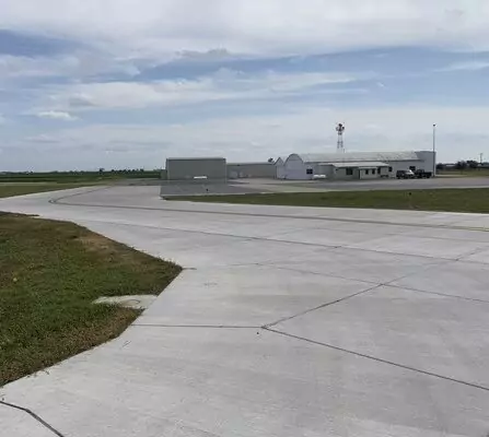 Airport taxiway with hangar in the background.