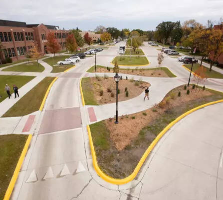 Sidewalks lined with pedestrians amidst urban landscaping