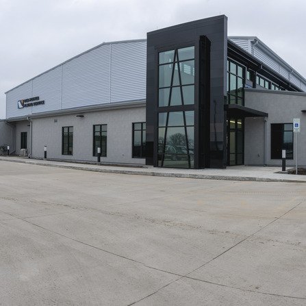 A modern airport exterior featuring large windows and contemporary architecture