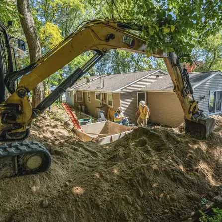 Workers excavating in residential area for lake sanitary collection system