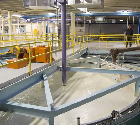 Water reclaim tank surrounded by pipes and railings