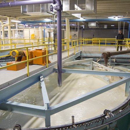 Water reclaim tank surrounded by pipes and railings