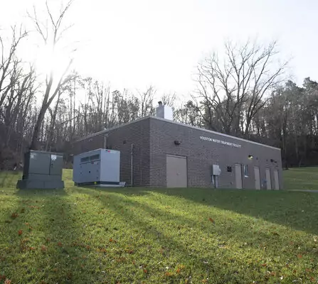 Brick building in a wooded area, with an electric box nearby