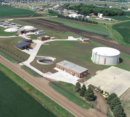 Aerial view of wastewater treatment facility with building and tanks