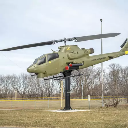 Helicopter monument next to a walking path with trees in the distance
