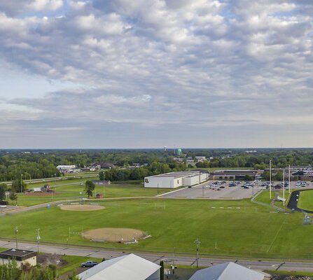 Bird's eye view of track, water tower, baseball field, and distant parking lots