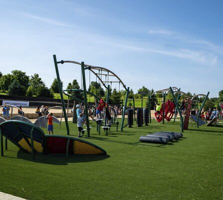 Children playing in a vibrant new park while parents observe