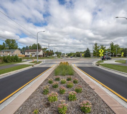 A landscaped median with a roundabout in the distance