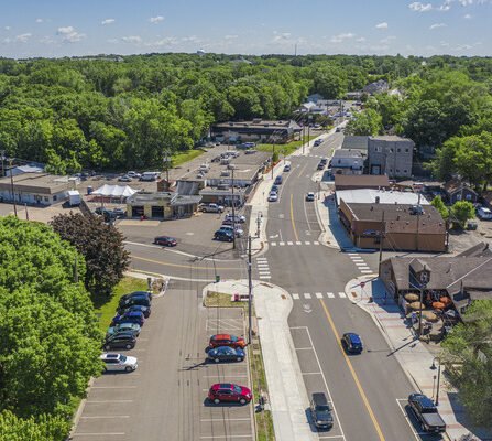 Aerial view of a business area with buildings, parking, roads, and greenery