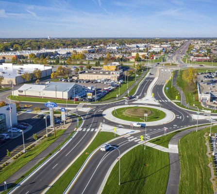 Aerial view of cars navigating a roundabout surrounded by buildings