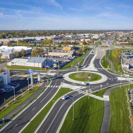 Aerial view of cars navigating a roundabout surrounded by buildings