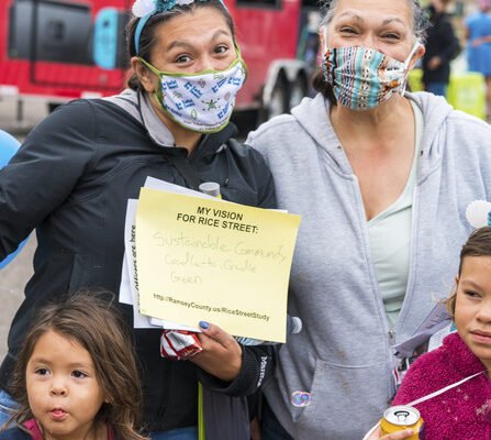 People wearing masks holding a sign