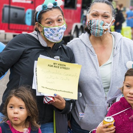People wearing masks holding a sign