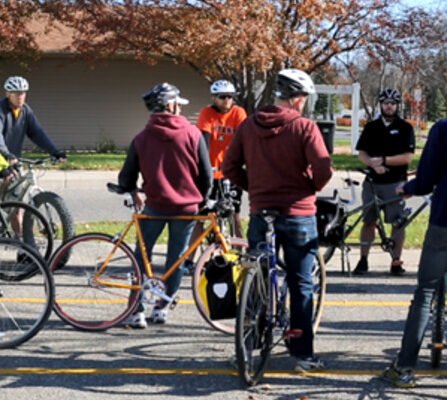 A group of cyclists gathered in a parking lot