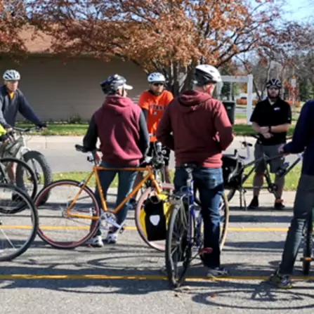 A group of cyclists gathered in a parking lot