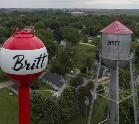 Aerial view of old and new water towers side by side, with trees in the background