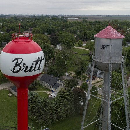 Aerial view of old and new water towers side by side, with trees in the background