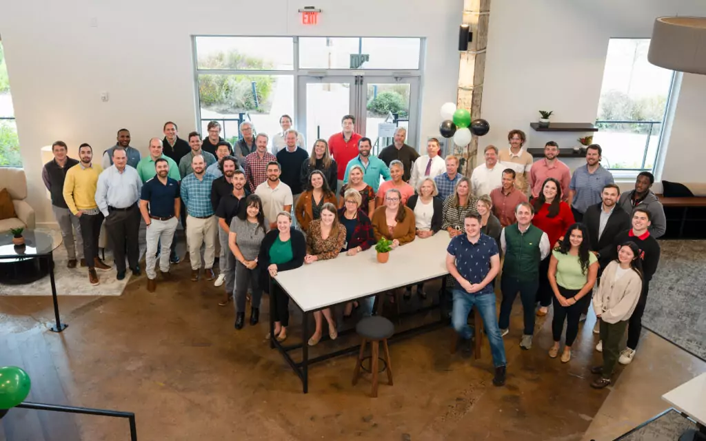 group picture of employees standing in new Charlotte office