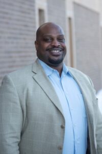 Man in gray suite looking at camera and smiling