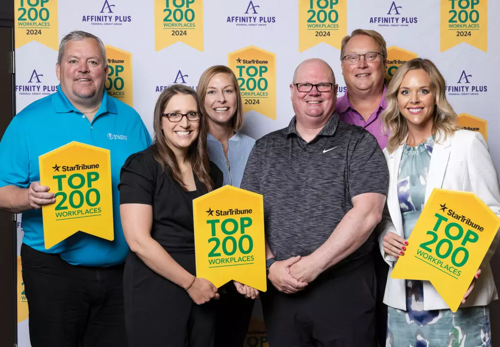Top 200 Workplaces of Minnesota Luncheon with a group of people holding yellow signs