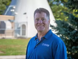 man in blue polo shirt smiling at camera