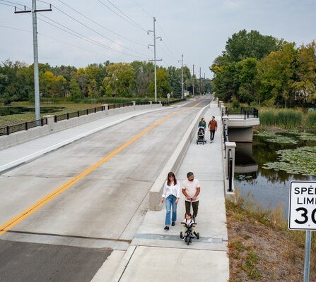 Pedestrians crossing bridge over narrow causeway