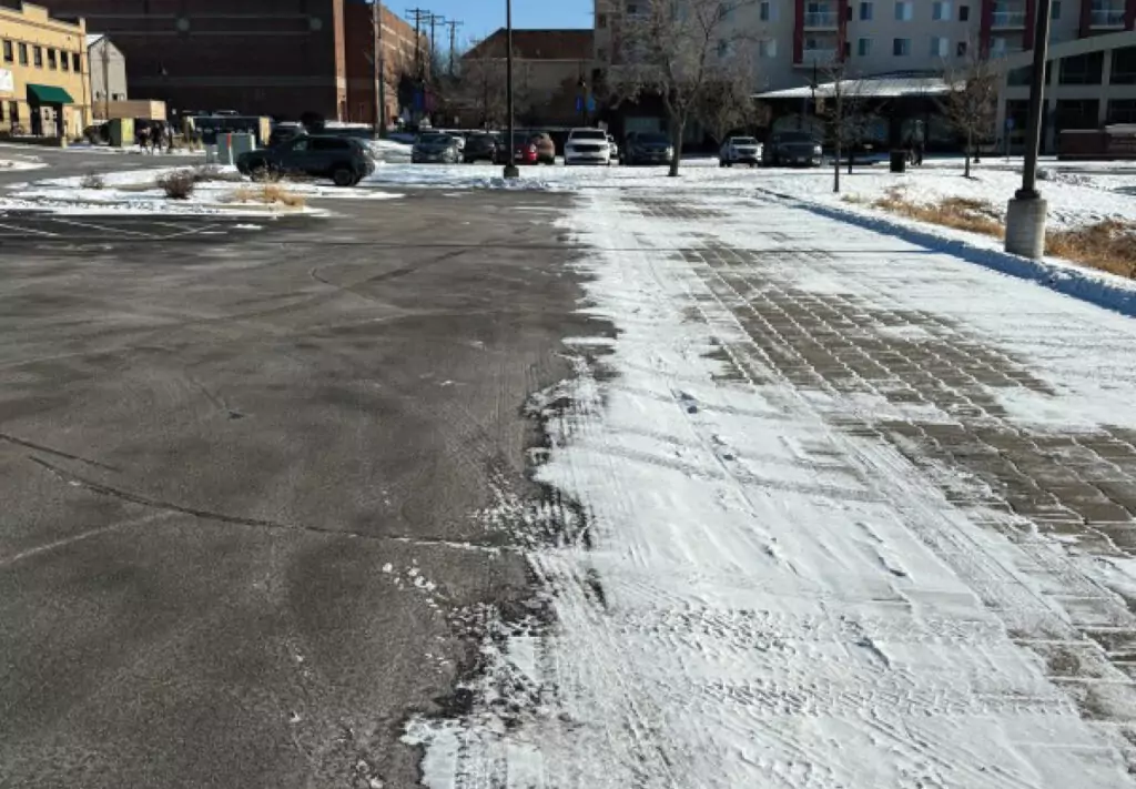 A parking lot with compacted snow on it