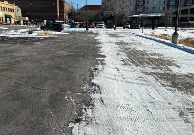 A parking lot with compacted snow on it