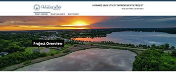 Aerial view of Howard Lake at sunset, with lush greenery and a shimmering body of water. The text reads Howard Lake Utility Improvements Project, featuring a Project Overview button. This stunning image highlights an essential Public Projects initiative against an orange and blue sky.